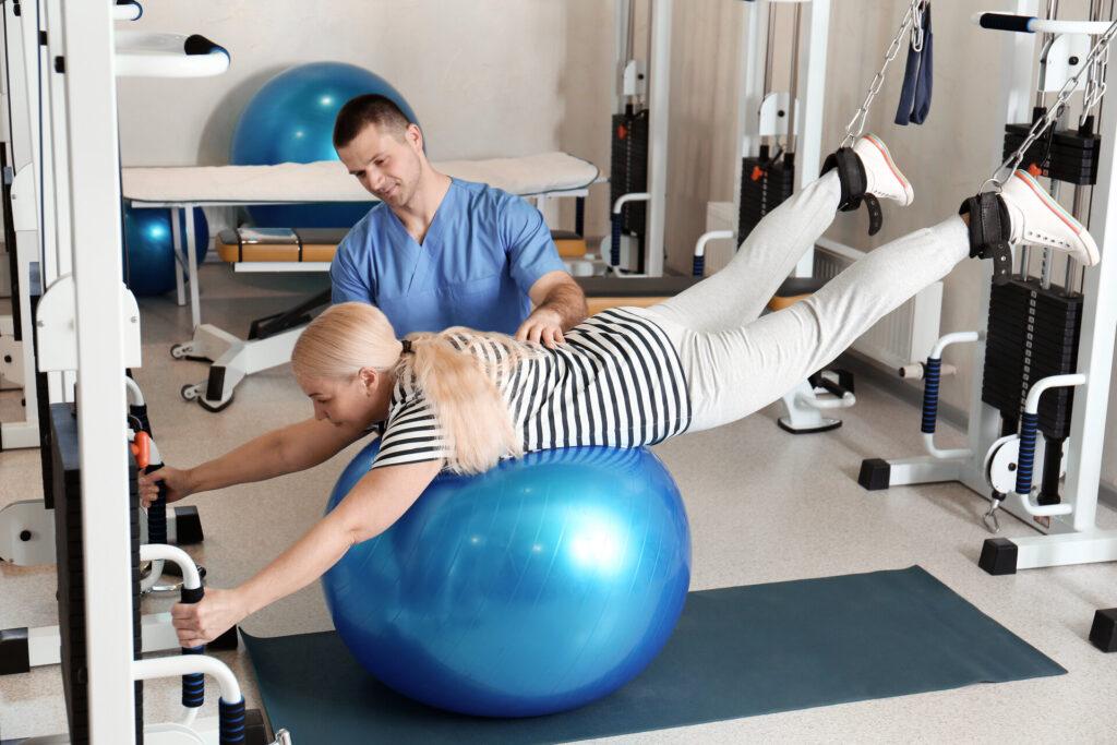 Patient beim Training unter Aufsicht eines Physiotherapeuten im Rehabilitationszentrum