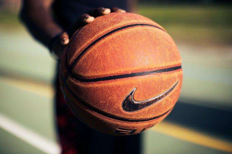 Eine Person hält einen braunen Nike-Basketball