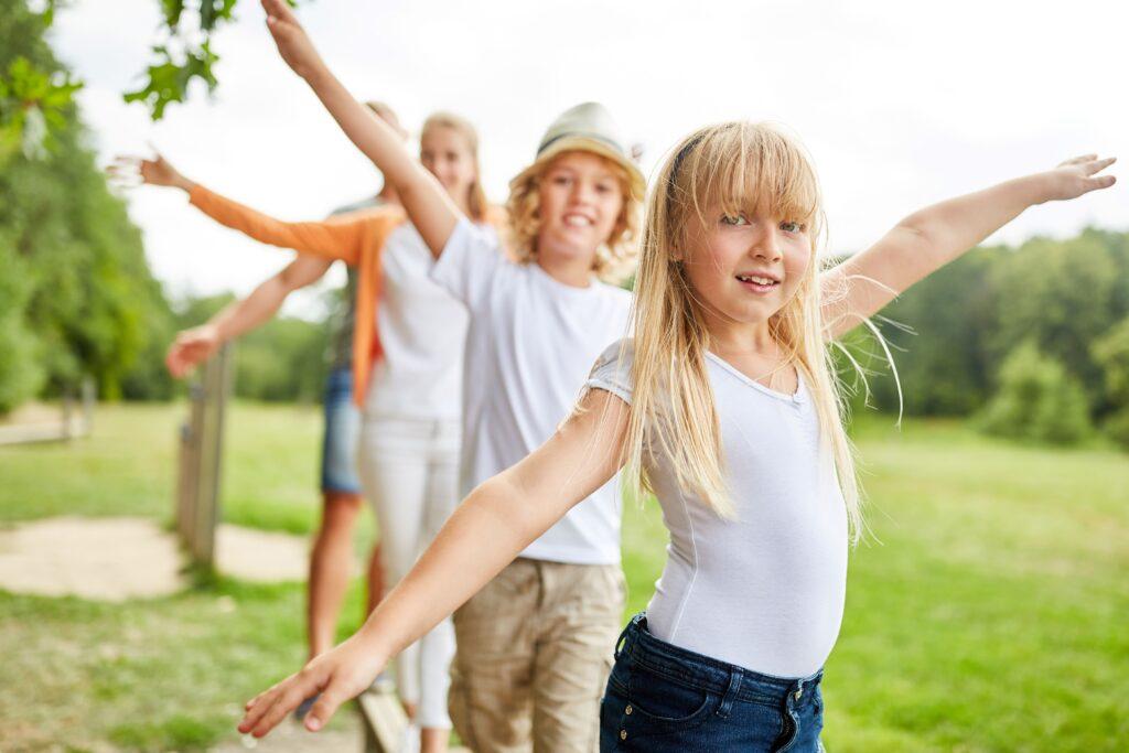 Kinder die auf dem Spielplatz balancieren