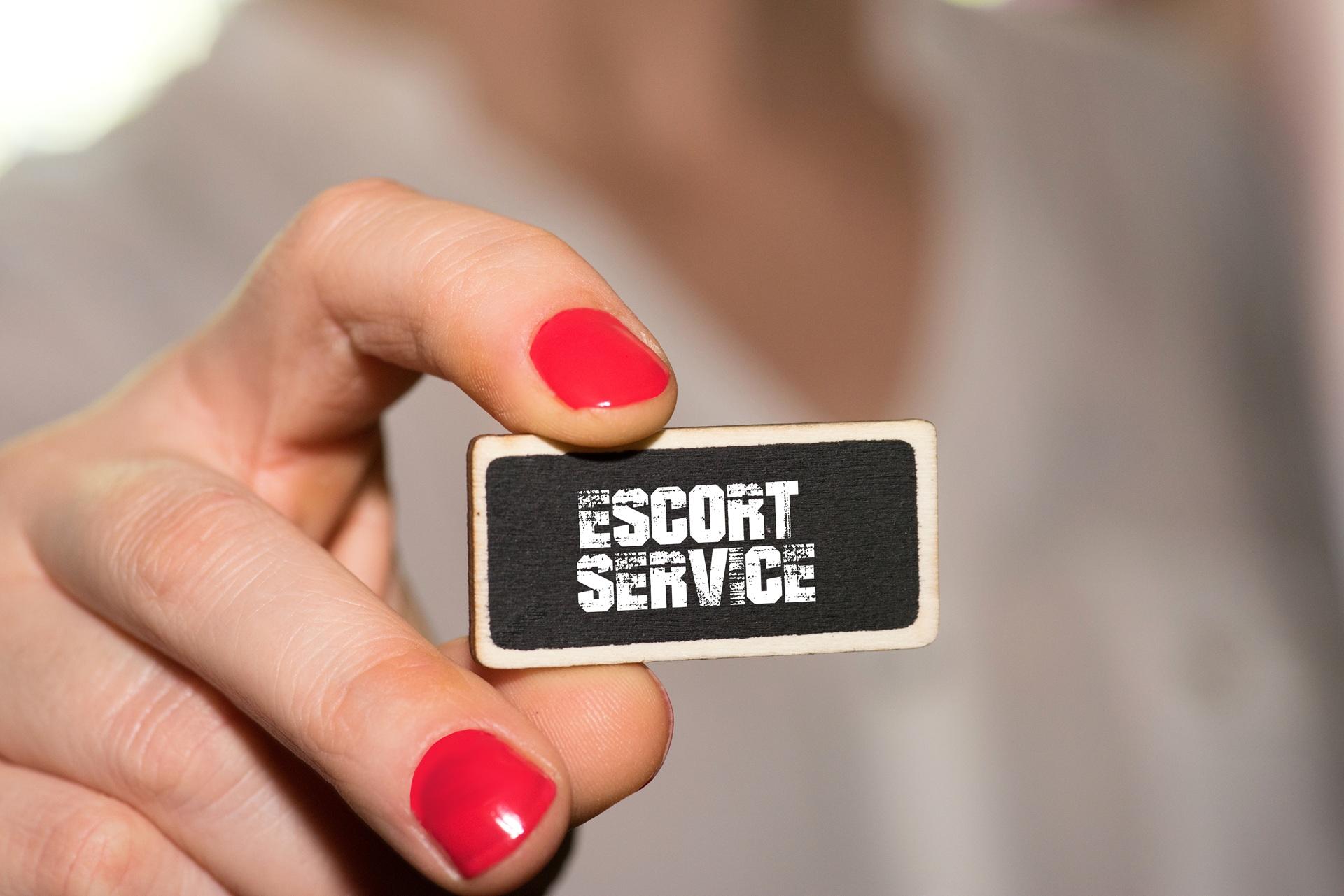 Frau zeigt Schild mit Aufdruck Escort Service | Dresden Escort 